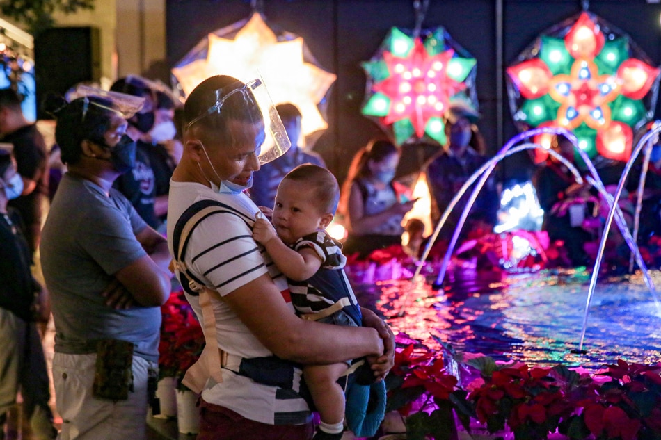 People wait in front of the giant Christmas Tree as Resorts World Manila opens Grand Fiesta Manila at the Newport Mall in Pasay City on November 11, 2021. George Calvelo, ABS-CBN News