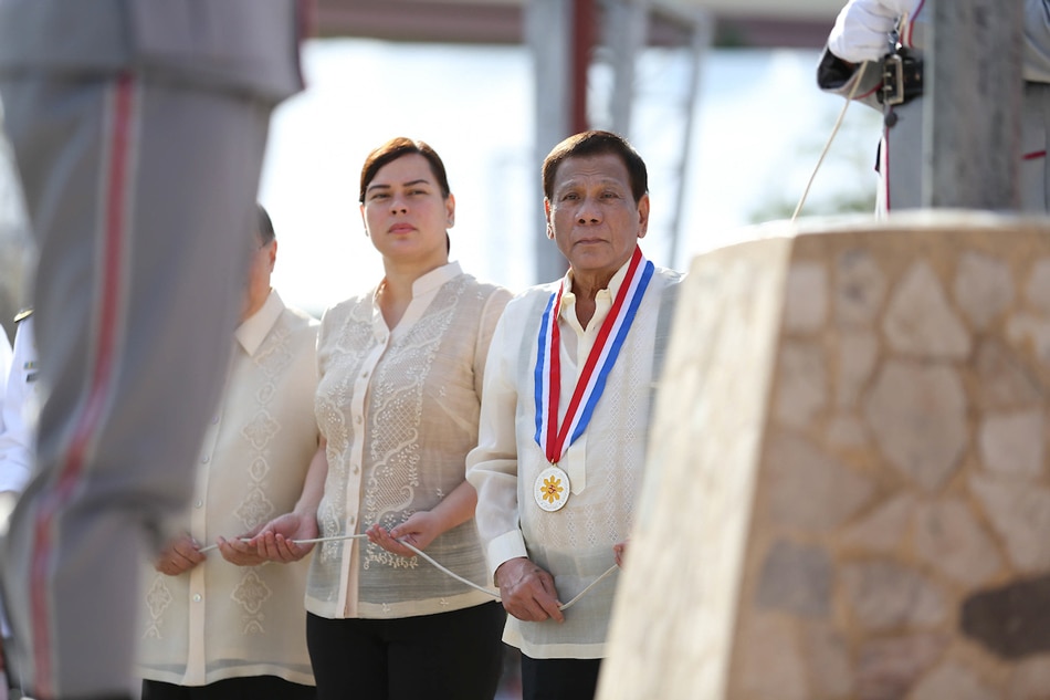 President Rodrigo Duterte leads the flag-raising ceremony during the commemoration of the 123rd Anniversary of the martyrdom of Dr. Jose Rizal at the Rizal Park in Davao City on Dec. 30, 2019. Assisting the President is Davao City Mayor Sara Duterte-Carpio. Karl Norman Alonzo, Presidential Photo/File 