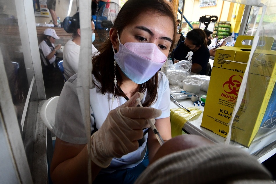 Quezon City residents receive their COVID-19 vaccine dose at the Batasan Hills National High School on Nov. 29, 2021, the start of the 