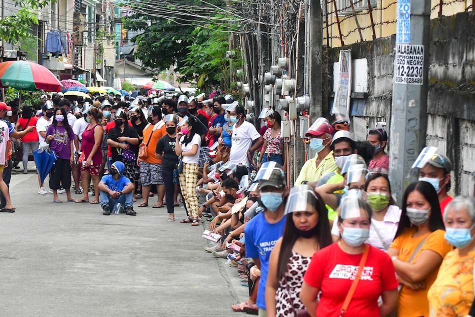 Quezon City residents queue for their COVID-19 vaccine dose at the Batasan Hills National High School on November 29, 2021, the start of the 