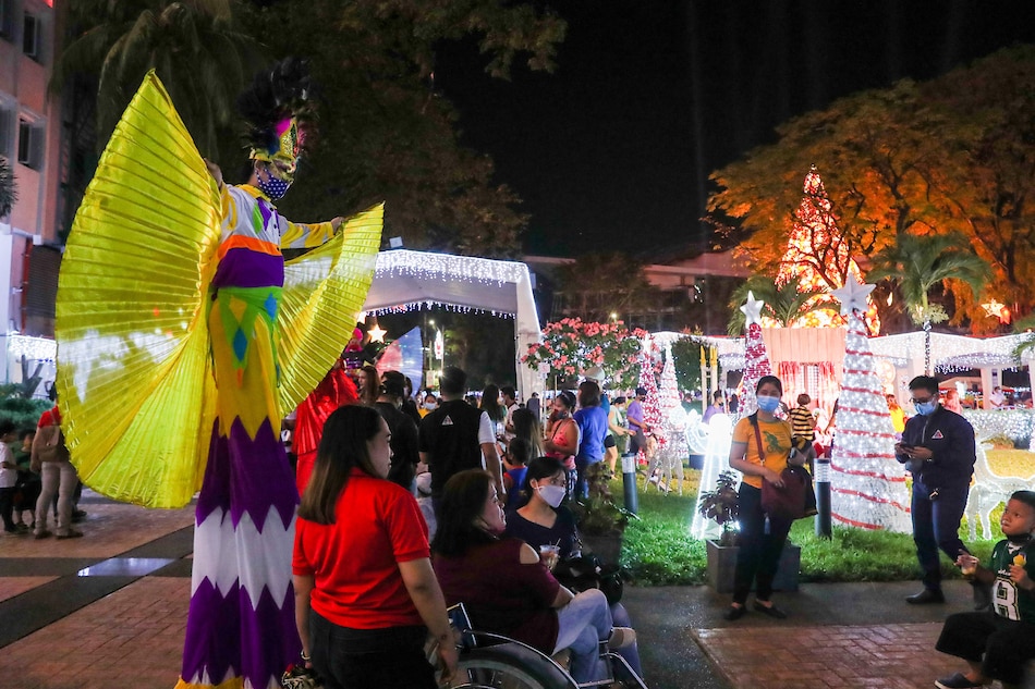 Ine-enjoy ng ilan ang mga Christmas attraction sa Quezon City hall sa Quezon City, sa kasagsagan ng COVID-19 pandemic. Jonathan Cellona, ABS-CBN News/File