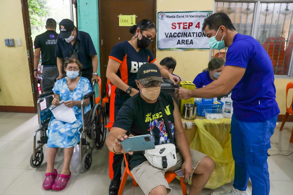Manila residents line-up for COVID-19 vaccine
