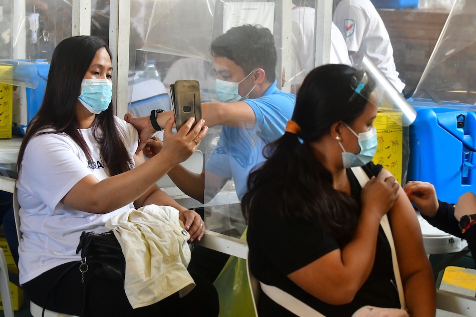Quezon City residents receive their COVID-19 vaccine dose at the Batasan Hills National High School on November 29, 2021, the start of the 