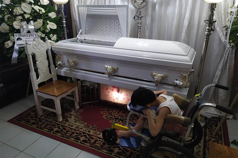 Gabriel Santos, an 11-year-old child with cerebral palsy, in his father’s wake who succumbed to cancer on Father