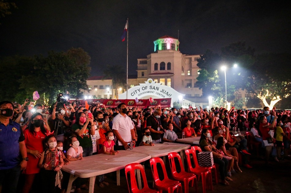 People watch the fireworks display at the San Juan City hall grounds on December 3, 2021. The city kicked off its Christmas celebration with a Christmas tree lighting, fireworks display, and their annual Christmas bazaar, which will be open from December 3 to January 1, 5 p.m. to 12 midnight daily. George Calvelo, ABS-CBN News