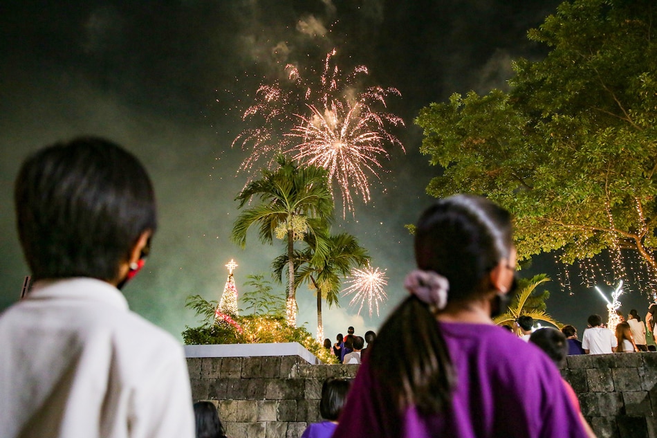 People watch the fireworks display at the San Juan City hall grounds on Dec. 3, 2021. The city kicked off its holiday celebration with a Christmas tree lighting, fireworks display, and an annual bazaar. George Calvelo, ABS-CBN News