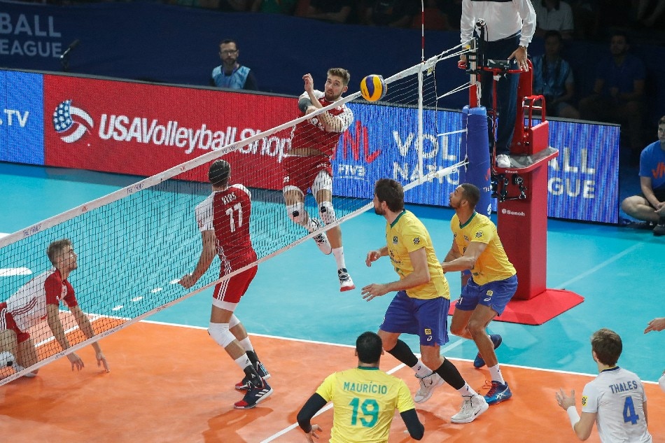 Poland's Bartosz Bednorz (C) hits the ball against Brazil during the FIVB Volleyball Nations League third place game in Chicago, Illinois, July 14, 2019. Kamil Krzaczynski, AFP