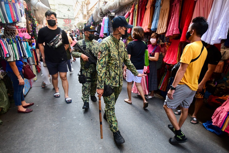 PNP officers patrol the streets reminding people of social distancing in the Divisoria shopping area in Manila on December 9, 2021. Mark Demayo, ABS-CBN News