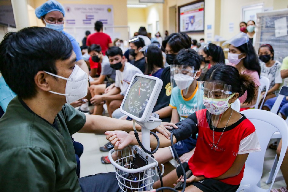 A health worker inspects the blood pressure of minors who just received their 2nd dose of Pfizer’s COVID-19 vaccine at the Ospital ng Tondo in Manila on December 4, 2021. George Calvelo, ABS-CBN News