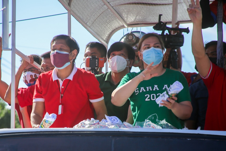 Presidential aspirant Ferdinand Marcos, Jr. and running-mate Davao City Mayor Sara Duterte-Carpio greet supporters during the team's grand caravan along Commonwealth Avenue in Quezon City on Dec. 8,2021. Jonathan Cellona, ABS-CBN News