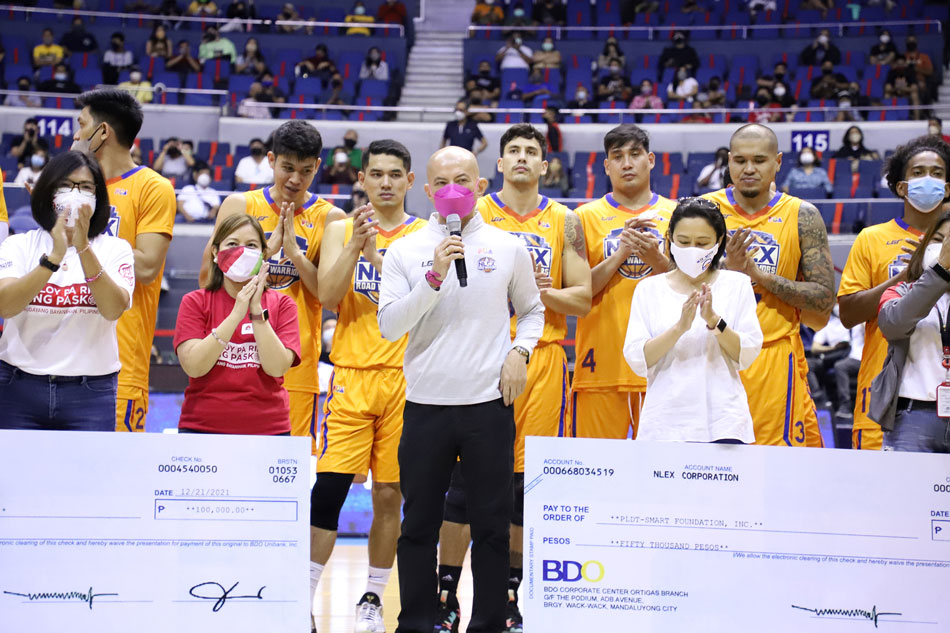 The NLEX Road Warriors, led by Coach Yeng Guiao, turned over checks amounting to P150,000 to a local foundation. PBA Media Bureau.