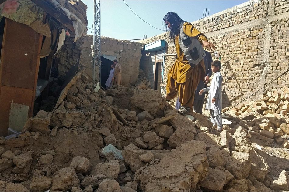 Residents gather next to the debris of their houses that collapsed following an earthquake in the remote mountainous district of Harnai, Pakistan on Thursday early morning. Banaras Khan, Agence France-Presse