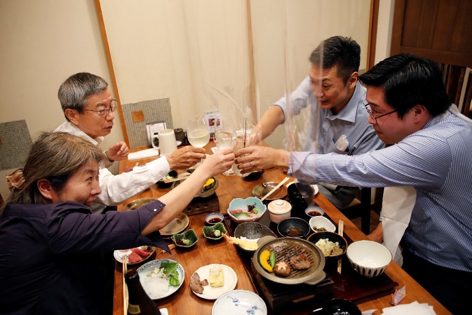 Yuji Shidara (2nd L) toasts with his colleagues during dinner at Japanese restaurant Kazu on the first day after Japan lifted the state of emergency imposed by COVID-19 outbreak, Japan, Oct. 1, 2021. Kim Kyung-Hoon, Reuters