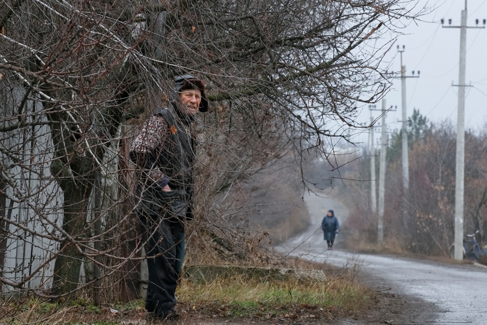 A local resident Vitaliy Kudla, 90, stands at a street near his house near the front line in the village of Zaitseve, in the Donetsk region, Ukraine December 17, 2021. Picture taken December 17, 2021. Gleb Garanich, Reuters