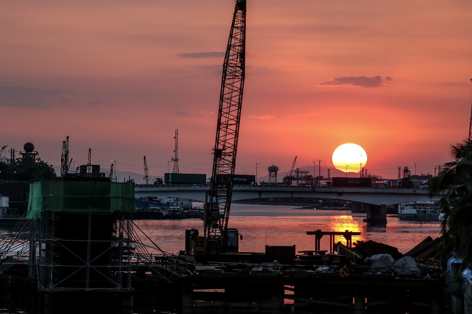 The sun sets while cargo trucks coming from the port area cross Roxas Bridge on R-10 Road, Manila on March 24, 2020. Fernando G. Sepe Jr., ABS-CBN News/File