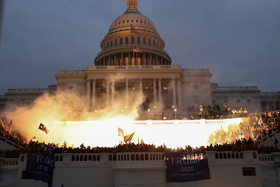 An explosion caused by a police munition is seen while supporters of US President Donald Trump gather in front of the US Capitol Building in Washington on January 6, 2021. Leah Millis, Reuters/File