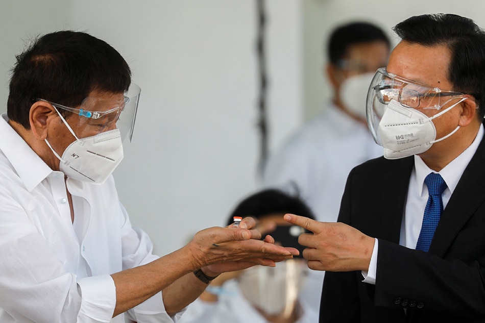 President Rodrigo Duterte and Chinese Ambassador Huang Xilian check a vial of Sinovac Biotech's CoronaVac vaccine during the arrival ceremony for the first shipment of coronavirus disease (COVID-19) vaccines to arrive in the country, at Villamor Air Base, Pasay, Metro Manila, Feb. 28, 2021. Eloisa Lopez, Reuters/File