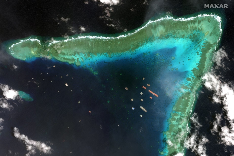 This handout satellite imagery taken on March 23, 2021 and received on March 25 from Maxar Technologies shows Chinese vessels anchored at the Julian Felipe Reef (Whitsun Reef) around 320 kilometers (175 nautical miles) west of Bataraza in Palawan in the West Philippine Sea. Agence France-Presse/handout