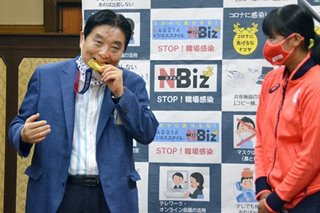 Japan mayor under fire for biting Olympian's gold medal