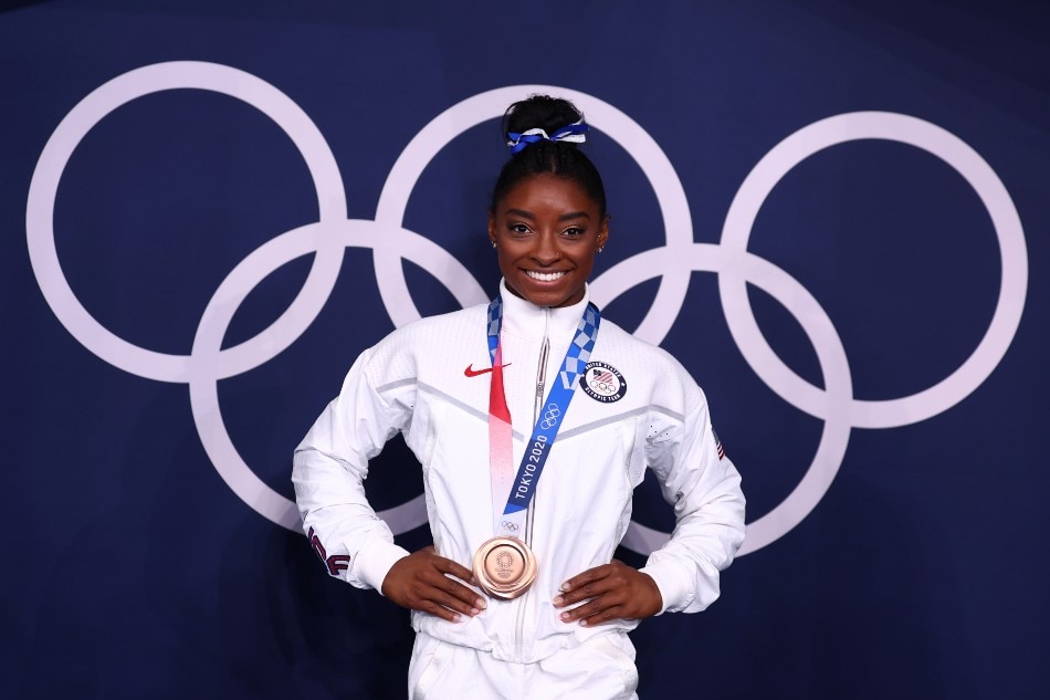 Bronze medalist Simone Biles of the United States poses in front of the Olympic rings. Mike Blake, Reuters.