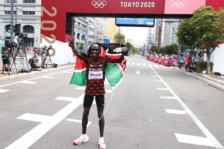 Eliud Kipchoge holds the flag of Kenya and celebrates after winning gold. Kim Hong-Ji, Reuters
