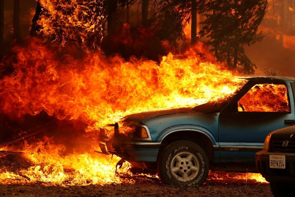 Wind-driven flames shoot horizontally out of the windshield of a car on fire at the Dixie Fire, a wildfire near the town of Greenville, California, US, Aug. 5, 2021. Fred Greaves, Reuters