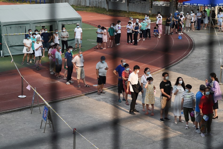 Residents line up at a nucleic acid testing site during a citywide mass testing following new cases of the coronavirus disease (COVID-19) in Wuhan, Hubei province, China, August 3, 2021. Picture taken August 3, 2021. Reuters/Stringer
