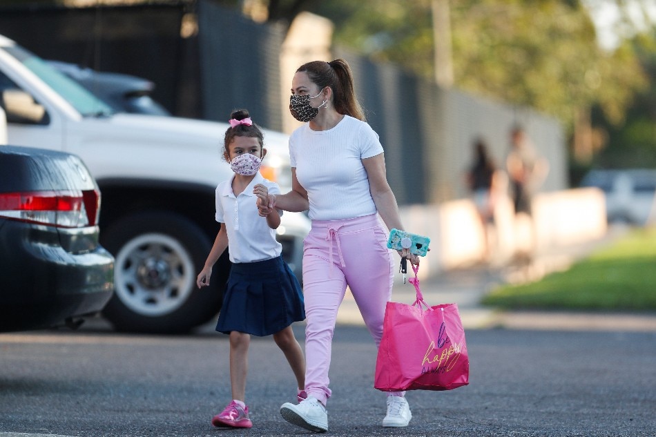 A mother walks her daughter on the first day of school, amid the coronavirus (COVID-19) pandemic, at West Tampa Elementary School in Tampa, Florida, U.S. Octavio Jones, Reuters