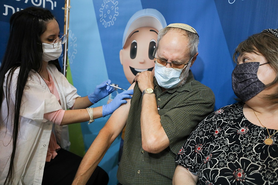 A man receives his third dose of the COVID-19 vaccine at a Clalit health-care maintenance organization in Jerusalem, Aug. 11, 2021. Ammar Awad, Reuters