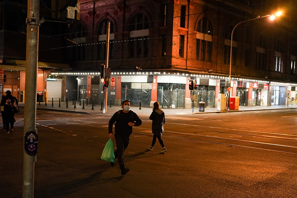 A man wearing a protective face mask jogs across a quiet city center street during a lockdown to curb the spread of a coronavirus disease (COVID-19) outbreak in Sydney, Australia, August 12, 2021. Loren Elliott, Reuters