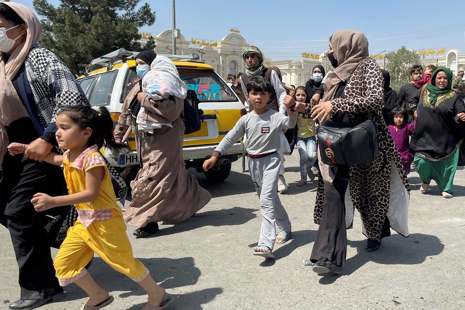 Women with their children try to get inside Hamid Karzai International Airport in Kabul, Afghanistan August 16, 2021 