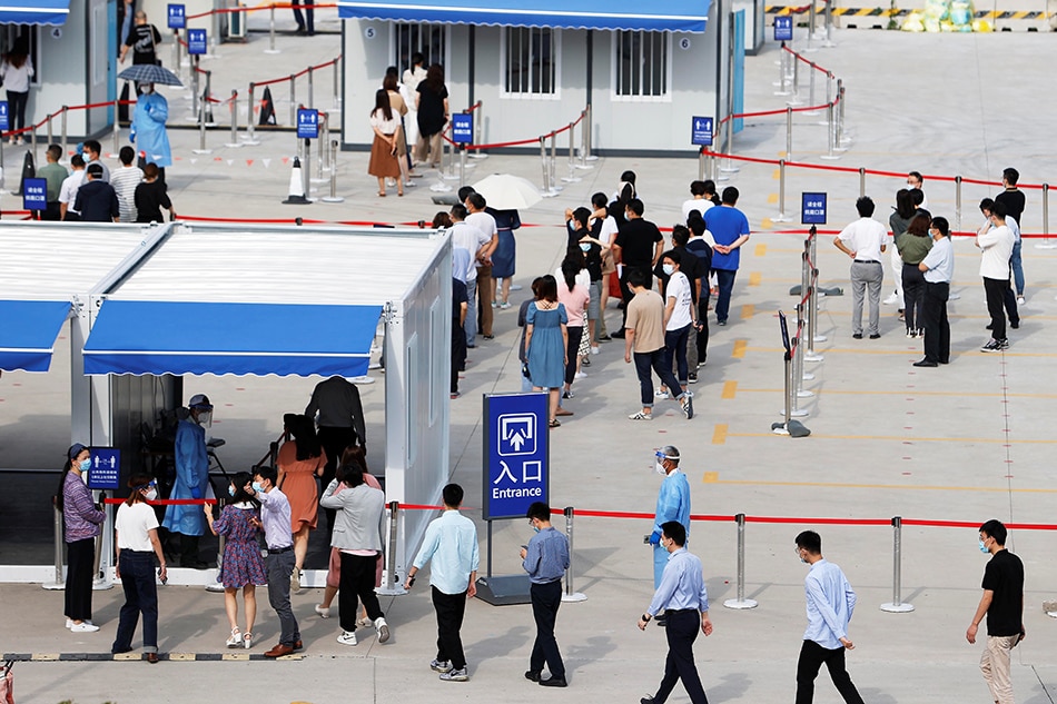Staff members of Shanghai Pudong International Airport line up at a nucleic acid testing site to test for the coronavirus disease (COVID-19) in Shanghai, China August 20, 2021. Picture taken August 20, 2021. cnsphoto via Reuters