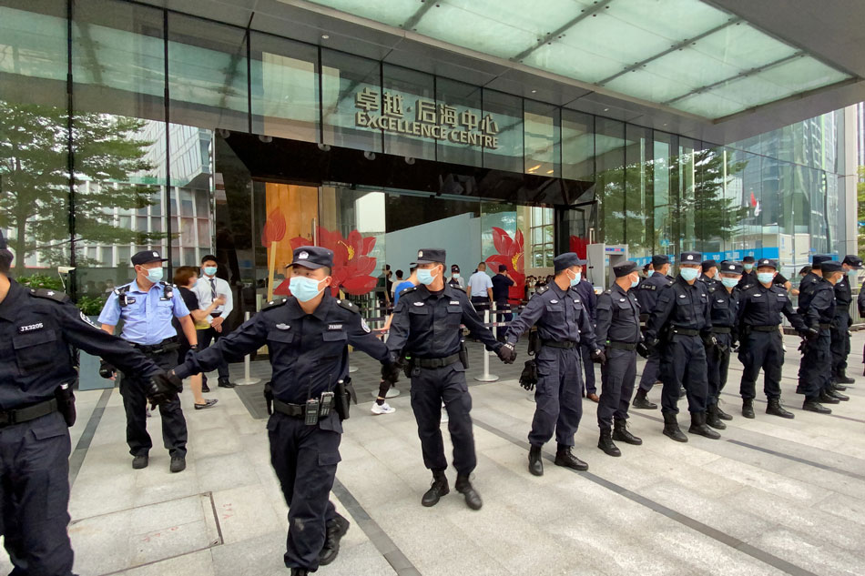 Security personnel form a human chain as they guard outside the Evergrande's headquarters, where people gathered to demand repayment of loans and financial products, in Shenzhen, Guangdong province, China September 13, 2021. David Kirton, Reuters