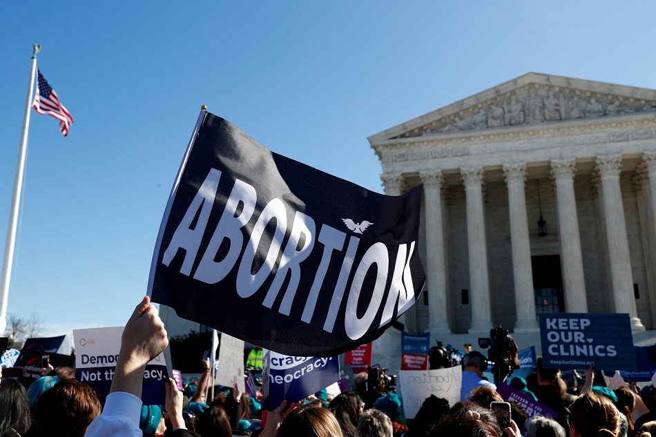 A demonstrator holds up an abortion flag outside of the US Supreme Court as justices hear a major abortion case on the legality of a Republican-backed Louisiana law that imposes restrictions on abortion doctors, on Capitol Hill in Washington, March 4, 2020. Tom Brenner, Reuters/file