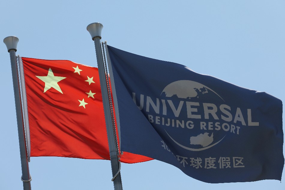Chinese national flag flutters next to a flag of Universal Beijing Resort, ahead of the resort's opening in Beijing, China, August 27, 2021. Tingshu Wang, Reuters/file