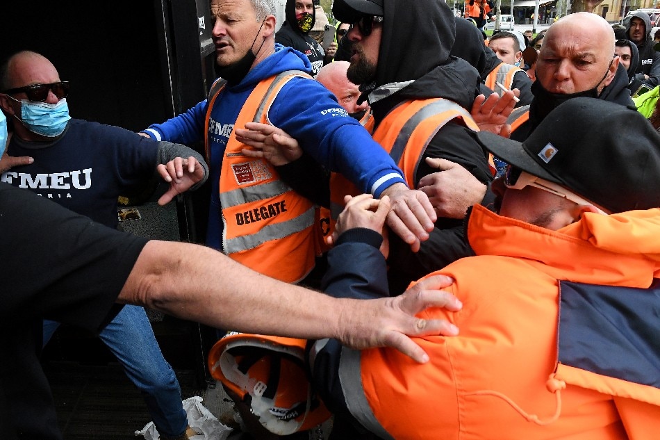 Construction workers clash with unionists while protesting work-related coronavirus disease (COVID-19) restrictions at Construction, Forestry, Maritime, Mining and Energy Union (CFMEU) headquarters in Melbourne, Australia, September 20, 2021. AAP Image/James Ross via Reuters