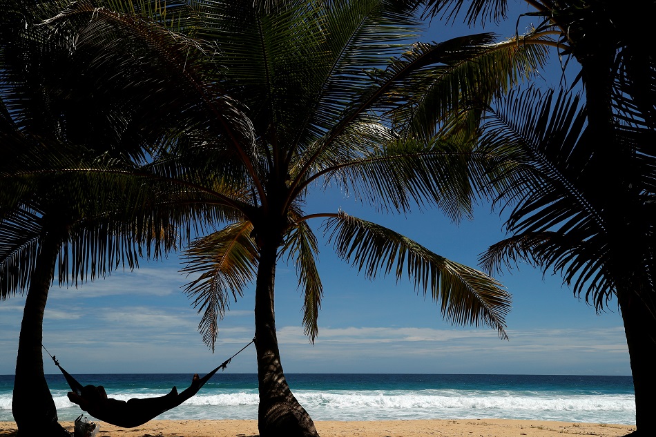 A man relaxes on Karon beach as Phuket gets ready to open to overseas tourists from July 1 allowing fully vaccinated foreigns to visit the resort island without quarantine, Phuket, Thailand June 29, 2021. Jorge Silva, Reuters/File