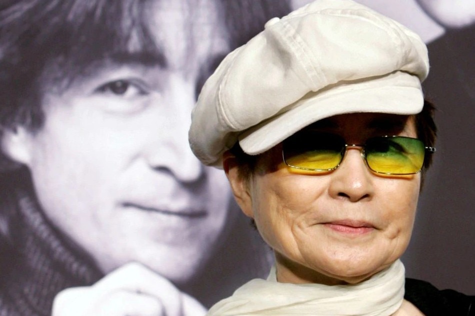 Yoko Ono, the wife of the late singer John Lennon, listens to reporter's questions in front of Lennon's portrait at a news conference in Tokyo October 4, 2005. Ono is in Japan to perform at the John Lennon Music Festival 2005 which will be held in Tokyo on October 7. REUTERS/Toru Hanai