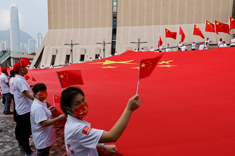 Pro-China supporters hold a giant Chinese flag on Chinese National Day, in Hong Kong, China, October 1, 2021.