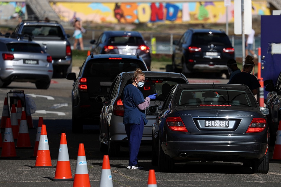 A health worker speaks with a person inside a vehicle at the Bondi Beach drive-through coronavirus disease (COVID-19) testing centre during a lockdown to curb the spread of a COVID-19 outbreak in Sydney, Australia, October 5, 2021. Loren Elliott, Reuters
