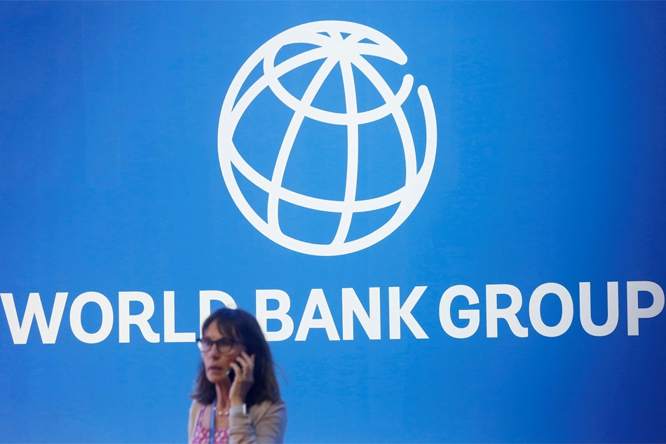 A participant stands near a logo of World Bank at the International Monetary Fund - World Bank Annual Meeting 2018 in Nusa Dua, Bali, Indonesia, October 12, 2018. Reuters, Johannes P. Christo/File Photo