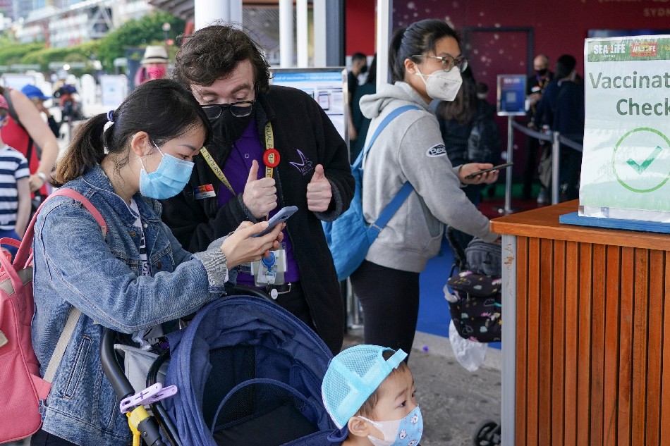 A staff member attends to a visitor at a vaccination check station at SEA LIFE Sydney Aquarium on the venue's first day of re-opening, following an extended closure due to coronavirus disease (COVID-19) lockdown orders, in Sydney, Australia, October 14, 2021. Loren Elliott, Reuters