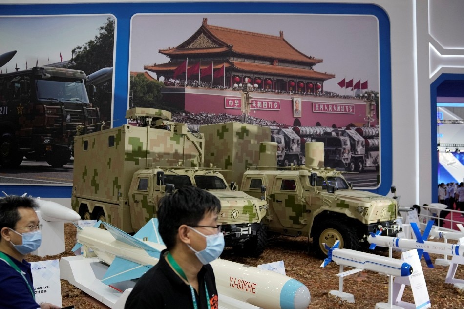 People walk past models of missiles and military vehicles displayed at the China International Aviation and Aerospace Exhibition, or Airshow China, in Zhuhai, Guangdong province, China, Sept. 28, 2021. Aly Song, Reuters