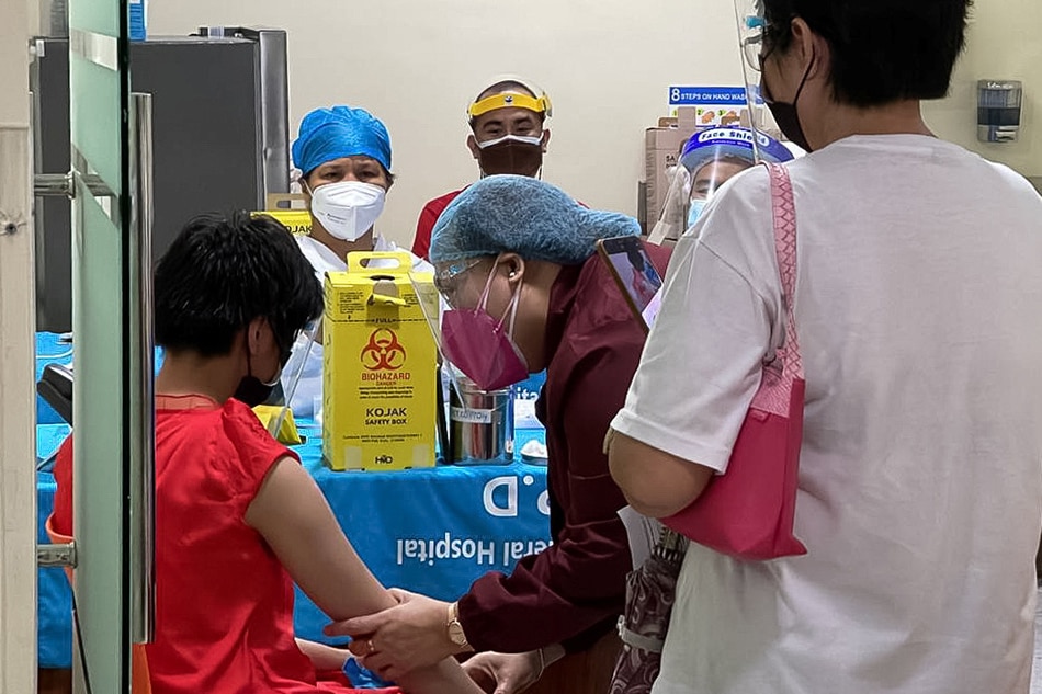A health worker prepares to inoculate a child with Pfizer-BioNTech vaccine against the coronavirus disease during the vaccine rollout for children with comorbidities, in Pasig on October 15, 2021. Pasig city information office handout via Reuters