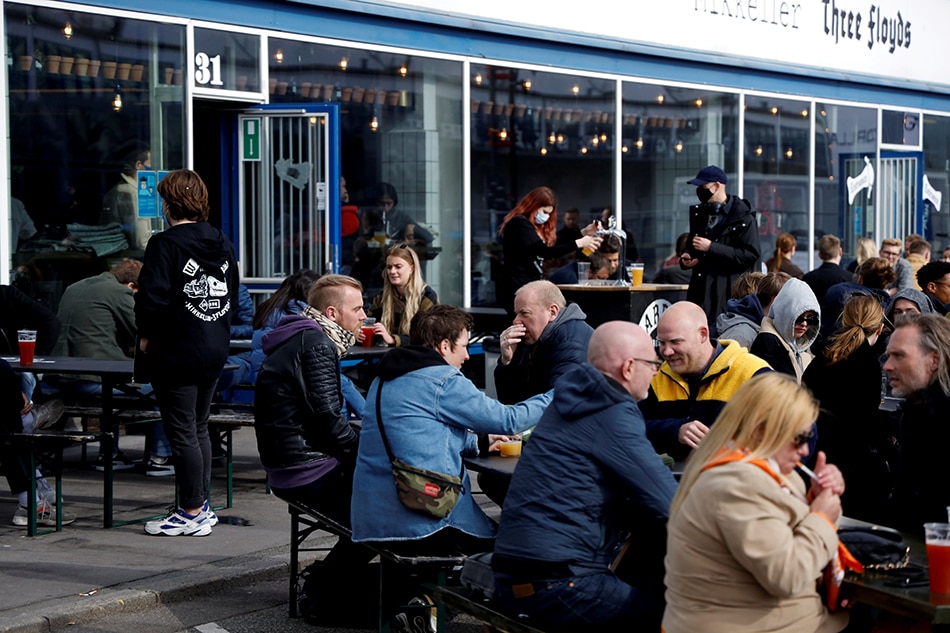 Customers sit outside a bar as a coronavirus disease (COVID-19) lockdown has been partially lifted in central Copenhagen, Denmark, April 23, 2021. Picture taken on April 23, 2021. Tim Barsoe, Reuters File Photo