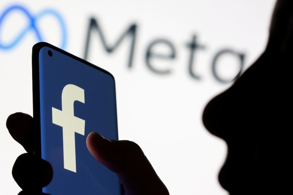 Woman holds smartphone with Facebook logo in front of a logo of Meta in this illustration picture taken October 28, 2021. Dado Ruvic, Reuters/Illustration/File Photo