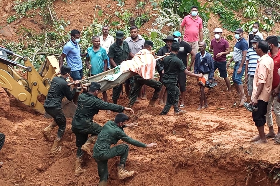  Sri Lanka army soldiers recover a body after a house collapsed due to a landslide caused by heavy rainfall in Galigamuwa, a divisional secretary area in Sri Lanka, November 10, 2021. Sri Lanka Army Media/ Handout via Reuters.