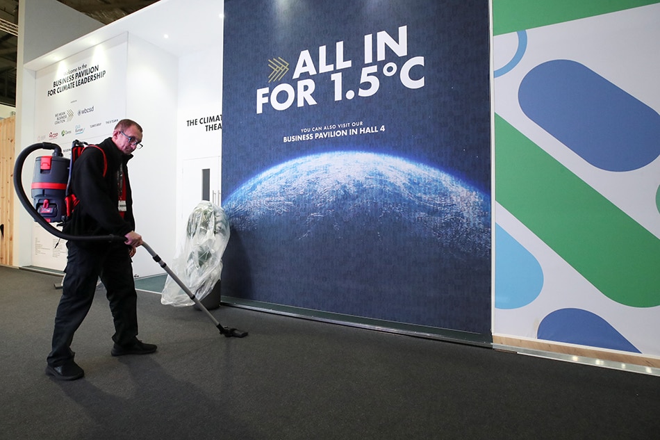 A worker is vacuuming the floor at the venue of the UN Climate Change Conference (COP26) in Glasgow, Scotland, Britain November 12, 2021. Yves Herman, Reuters