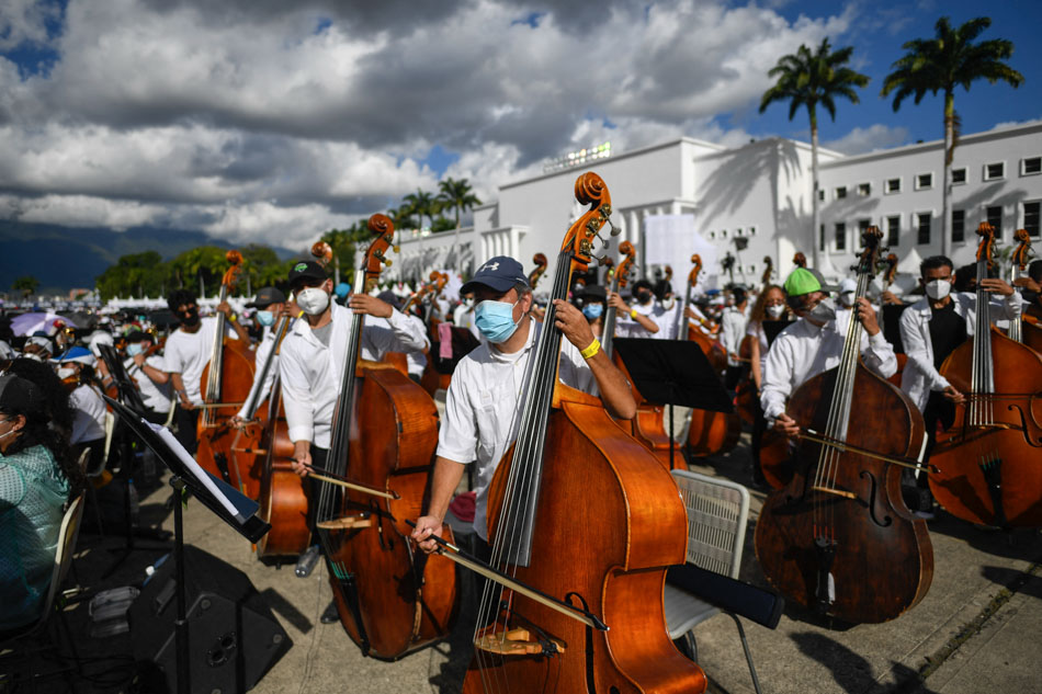 Members of the National System of Orchestras of Venezuela play during an attempt to enter the Guinness Book of Records for the largest orchestra in the world, at the Military Academy of the Bolivarian Army in Fuerte Tiuna Military Complex, in Caracas, on Nov. 13, 2021. At least 12,000 musicians participated in the event. Federico Parra, AFP