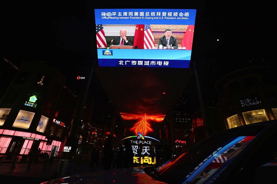 A screen in Beijing displays a CCTV state media news broadcast showing Xi and Biden during a virtual summit November 16, 2021. Thomas Peter, Reuters